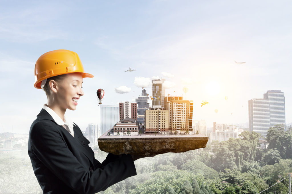 Young woman construction business owner in hardhat and suit holding architectural design. Women- and Minority-Owned Businesses